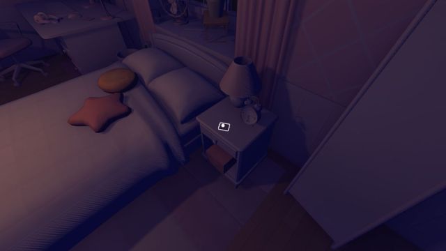 A shot looking down at a bedside cabinet with the Cartridge and a lamp on top of it, to the right of a bed