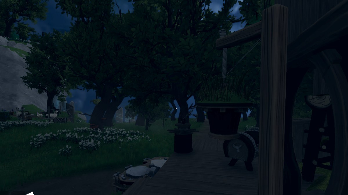 Aloft birdhouse strung from a wooden pole near trees and grass at night