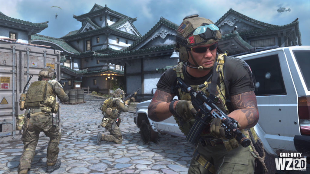A unit of troops with weapons stands next to a vehicle in a Japanese Pagoda-style courtyard and castle in DMZ.